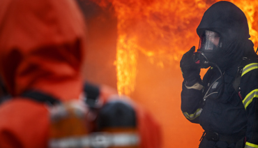 Brandman som pratar med kollegor vid brand
