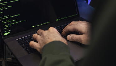 Man som kodar vid en dator