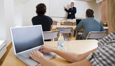 Personer i en skolsal med dator