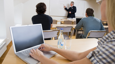 Personer i en skolsal med dator