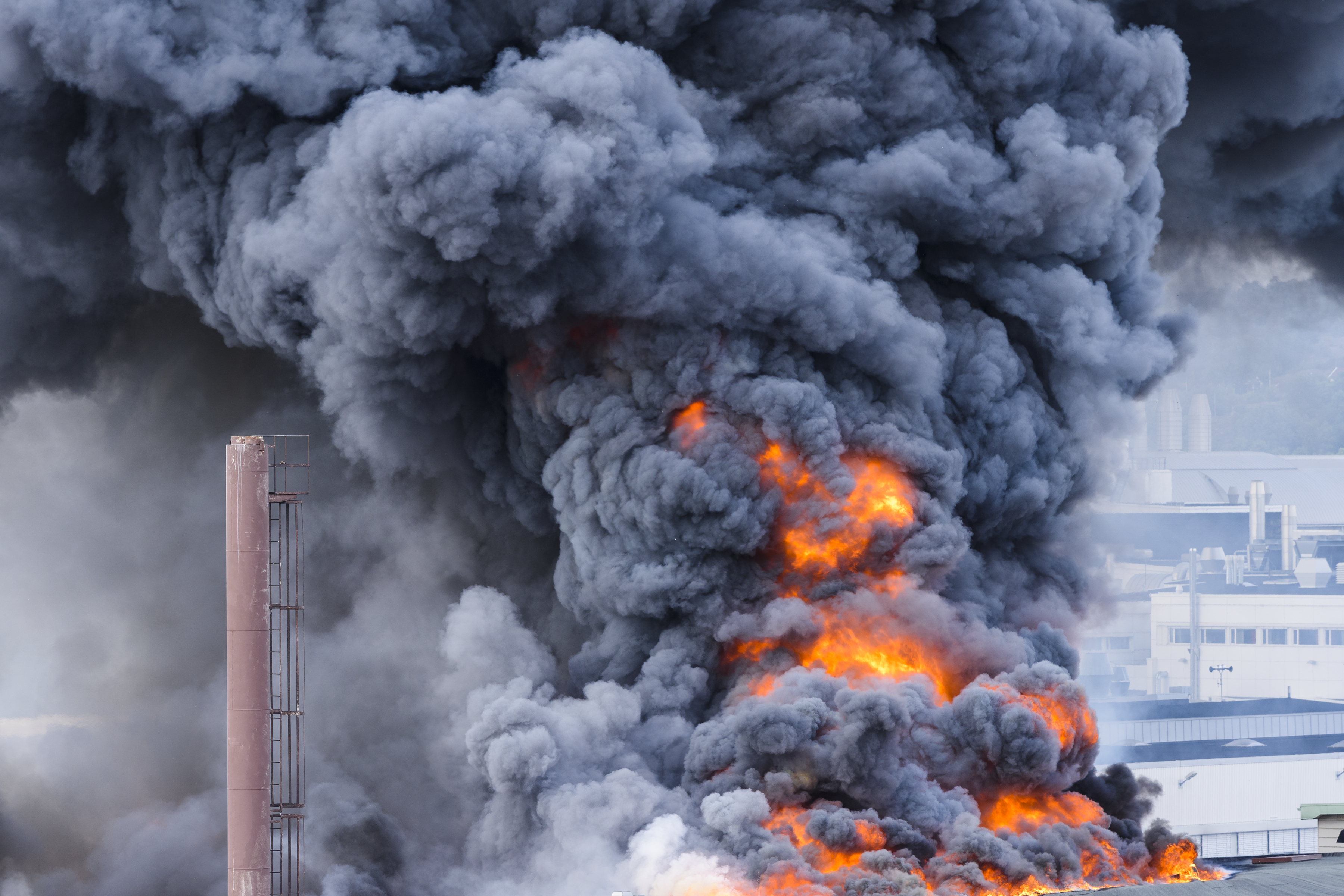 Stort rökmoln och brand i en byggnad