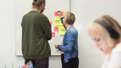 Människor vid en post-it-tavla