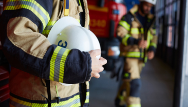 Räddningstjänstpersonal framför utryckningsfordon.
